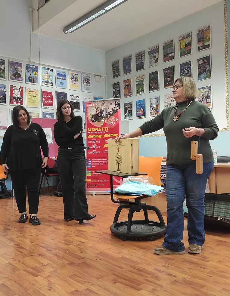 Operatrice presenta materiali agli studenti durante un laboratorio creativo del progetto CREA