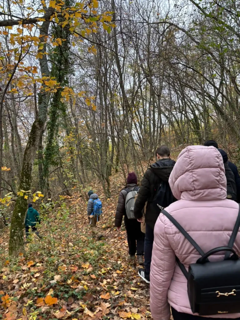 Partecipanti percorrono un sentiero nel bosco durante un’escursione naturalistica del progetto ECOSCENA