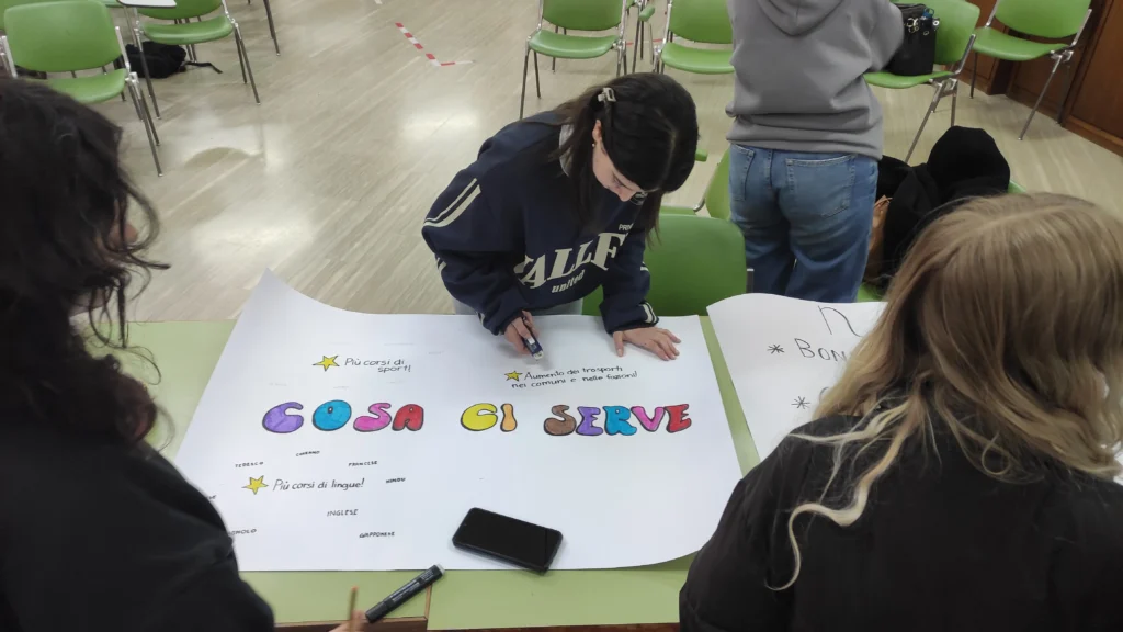 Studenti compilano il cartellone “Cosa ci serve” con proposte su sport, lingue e trasporti nel territorio