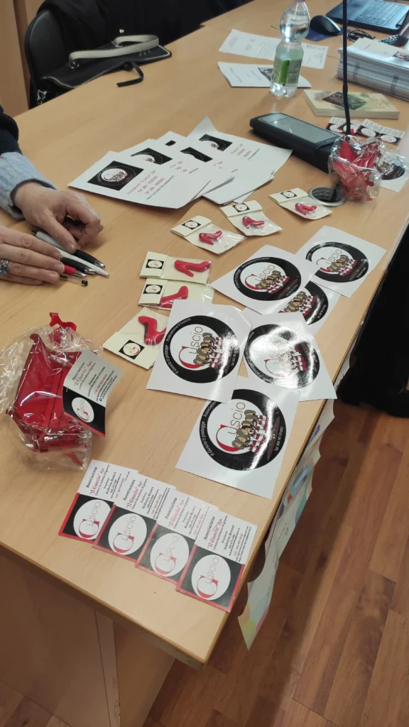Materiali informativi e nastri rossi utilizzati in un Lab Café di CREA sul tema della prevenzione della violenza di genere