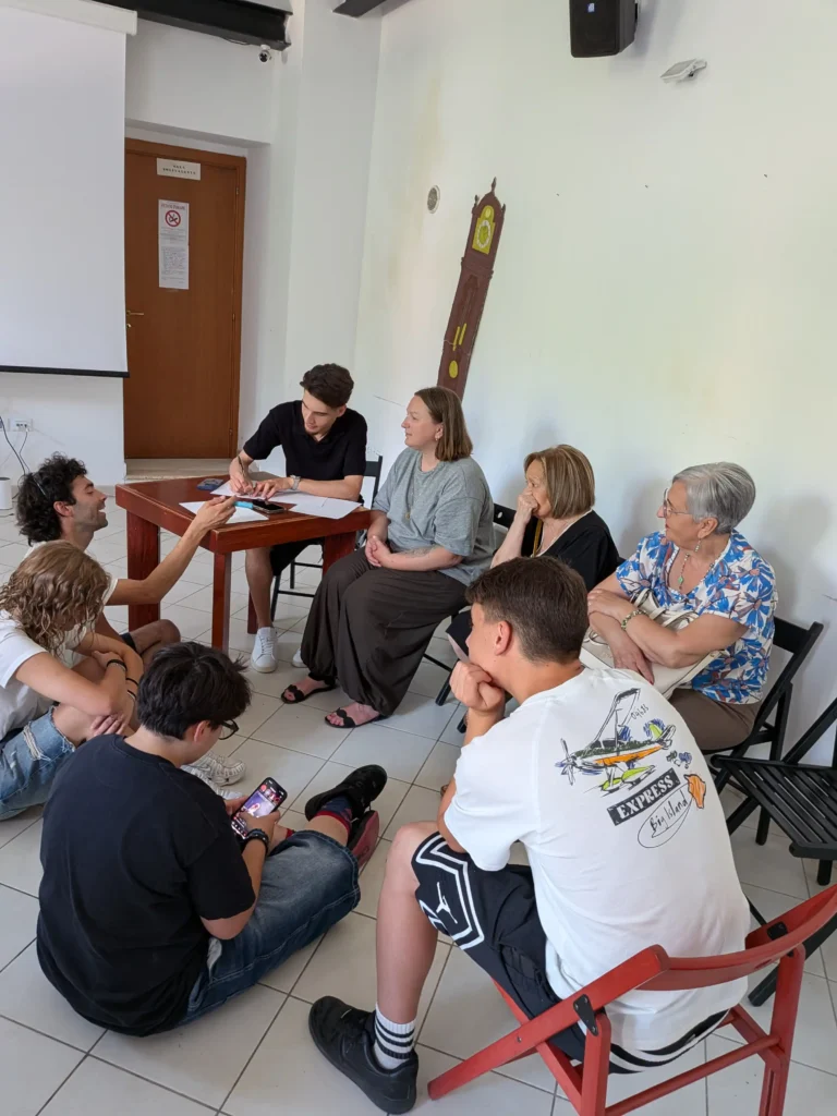 Giovani e adulti partecipano a un momento di confronto intergenerazionale nella sede dell’associazione Le 3 Porte
